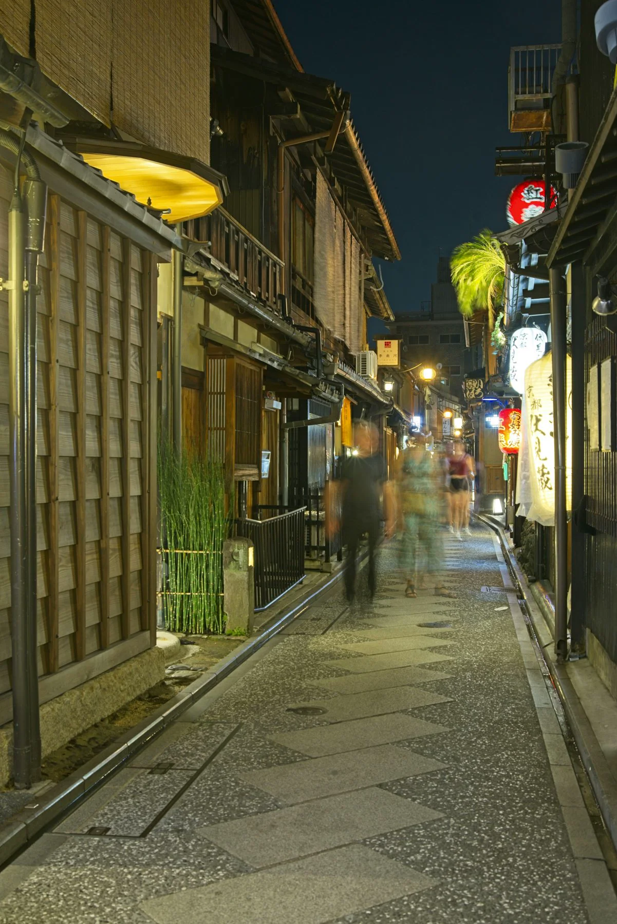Lanterns and wooden façades on a narrow Kyoto street at night